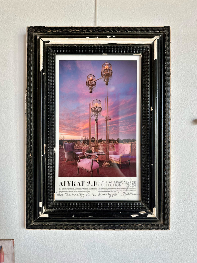 Framed poster of a sunset scene with outdoor furniture and lighting fixtures.